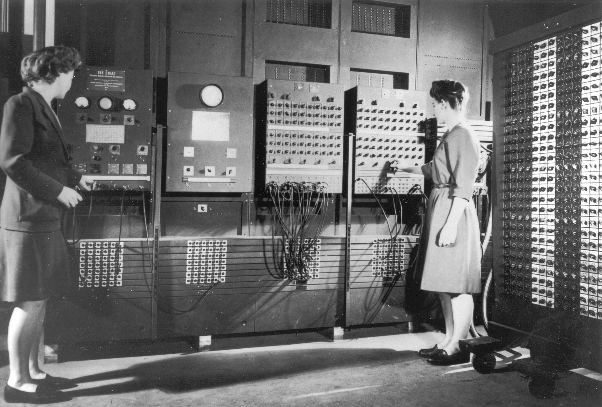 Two operators at the control panel of ENIAC